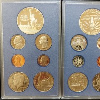 USA 1986-S: serie zecca 7 pezzi confezione ufficiale, con dollaro in argento "Ellis Island", in blister di plastica rigida